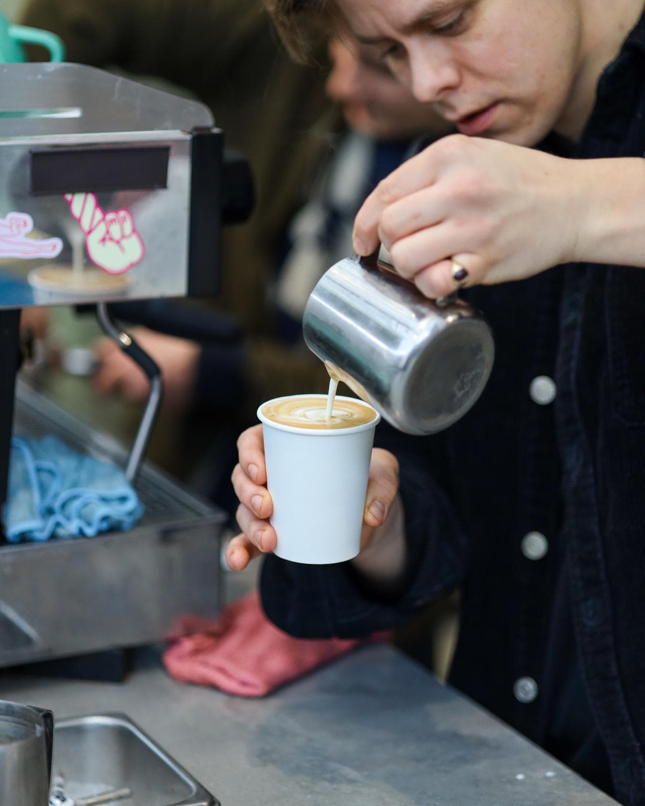 Niall pouring latte art into a paper cup