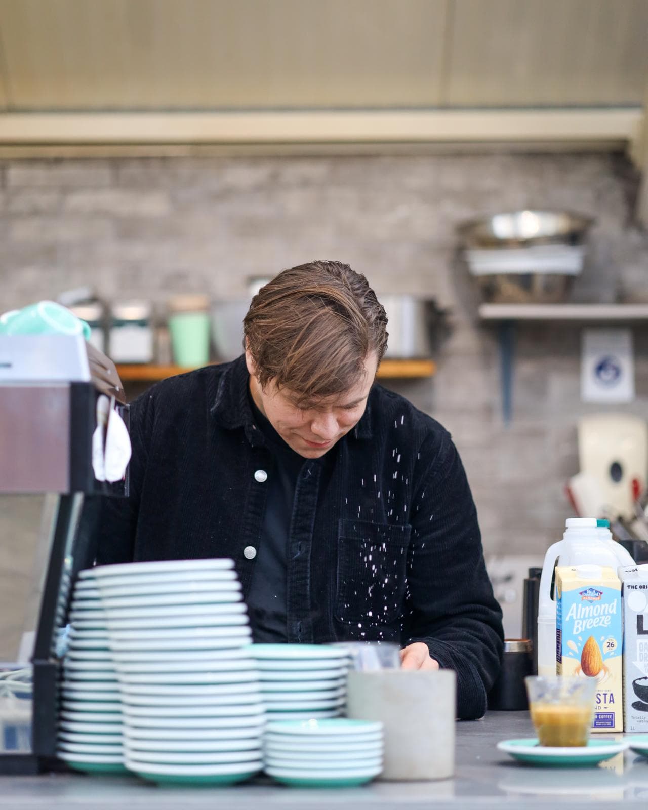 Niall behind the counter preparing coffee